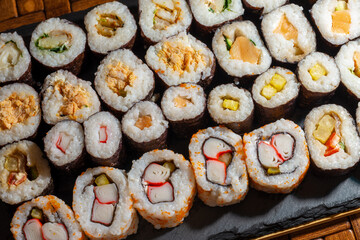 Set of sushi rolls on the slate serving tray