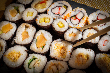 Assorted sushi rolls served on the slate tray