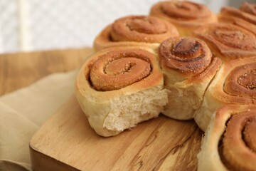 Freshly baked cinnamon rolls on wooden board, closeup