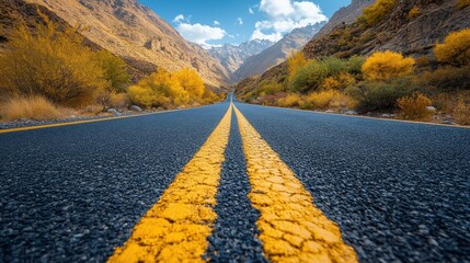 Serene mountain road with vibrant autumn foliage under a clear blue sky, inviting exploration