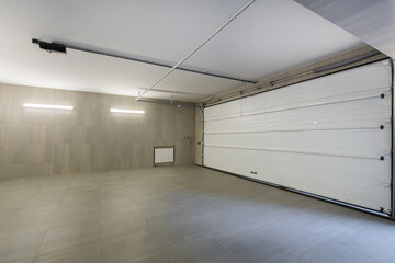 Spacious private garage decorated with light gray tiles. Wide automatic gates.