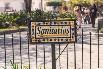 Obraz premium Tile sign pointing to public bathrooms in Antigua Guatemala.