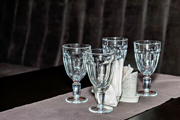 A table topped with four empty wine glasses and napkins