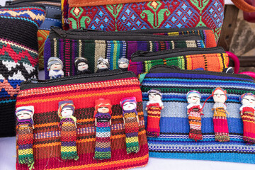 Hand bags made from colorful traditional woven cloth and decorated with worry dolls at a market near Lake Atitlan.
