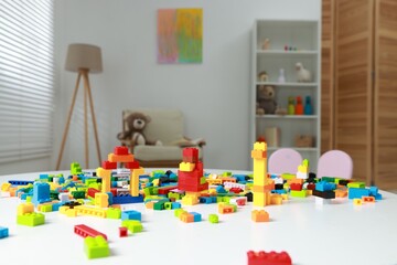 Construction toy. Figures made with building bricks and colorful blocks on white table indoors