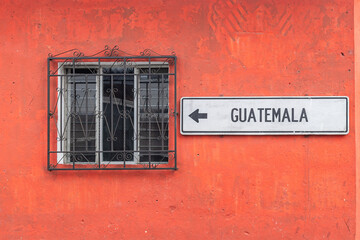 Sign saying Guatemala on a red painted building.
