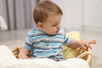 Fototapeta premium Cute baby boy in basket at home