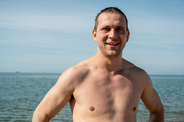 Happy 35 year old man, wet after swimming in the sea.