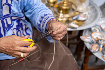 Man's hands working on metal filigree in the Blue City, Chefchaouen, Morocco