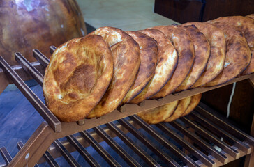 Freshly baked golden lavash displayed on wooden rack, highlighting traditional baking artistry....