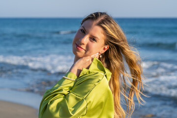 Young white woman in black bikini on the beach at sunset