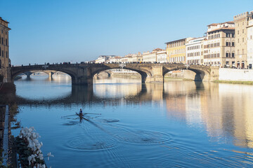 Rower under the bridge in Florence, Italy