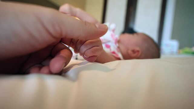 3 Month baby girl hand holding father hand during baby sleeping. newborn baby and dad hands. father taking care of his daughter kid happy family dream of health