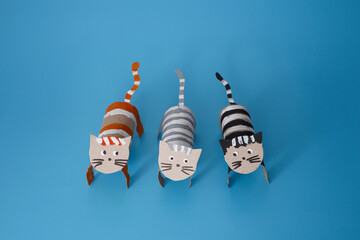 three handmade cat figures created from cardboard tubes. paper craft project highlights the fun and...