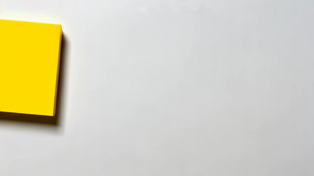 Bright yellow sticky note placed on a white wall indicating a reminder or important message