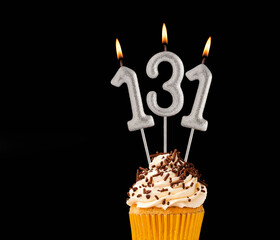 Number 131 shaped candles - Birthday cupcake on black background.
