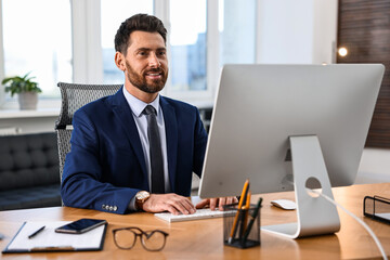 Obraz premium Man working on computer at table in office