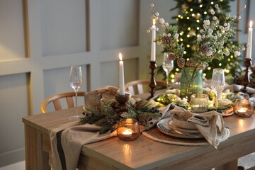 Christmas celebration. Festive table setting with dishware, glasses and decor in room