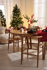 Christmas table setting with stylish dishware and festive decor indoors