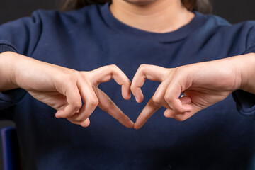 coeur fait avec les mains par une adolescente, affection, sentiments © Esta Webster