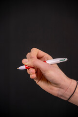 main d'un ado tenant un stylo couleur sur fond noir  © Esta Webster