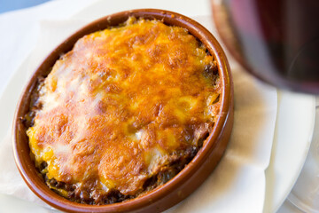 Baked ground beef with melted cheese in ceramic bowl