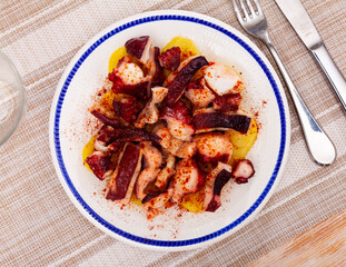 Tradicional Galician dish, pulpo a la gallega, served on plate.