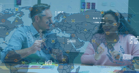 Image of world map and data over diverse male and female colleague at casual office meeting