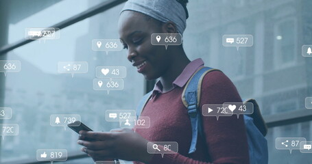 Image of media icons over african american woman using smartphone