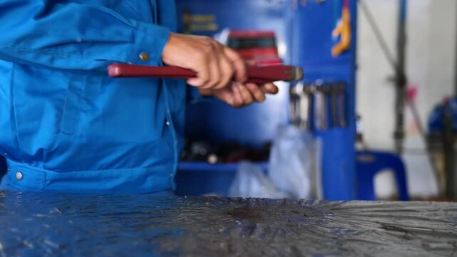 4K video of a technician using an adjustable wrench and storing it in a workshop tool cabinet. Ideal for maintenance tutorials, tool organization, and industrial training.