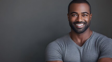 Fototapeta premium A happy smiling dark skinned man in a grey shirt