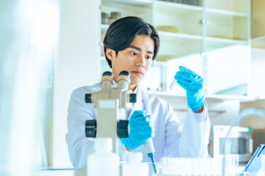 研究、科学者、男性、科学、調査、実験、顕微鏡、化学、試験管、ピペット、医薬品、製薬、白衣、学生、理系、大学、医学、医療、メディカル、病院、検査、実験室、研究所、ラボ、研究室、液体、スポイト、合成、検体、新薬、若い、日本人、研究者、研究員、手袋、バイオ、テクノロジー、開発、分析、実験器具、仕事、試験、医師、産業、働く、職場、シリアス、バイオテクノロジー、研究開発、人物