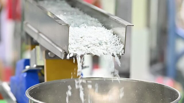 The slow motion scene of vibration conveyor deliver the recycle plastics.