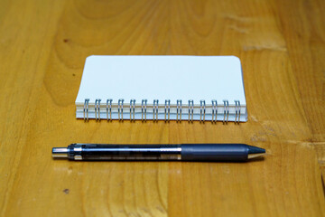 opened notebook paper with black pen on white desk, copy space