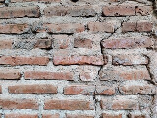 an old cracked and mossy brick wall
