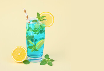 A vibrant blue summer cocktail garnished with fresh mint and lemon slices, set on a soft pastel beige background with ample copyspace for text. Ideal for beverage ads, menus, and social media posts.