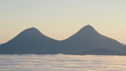 Majestic Twin Peaks Above a Sea of Clouds Mountain Range Aerial View Serene Landscape