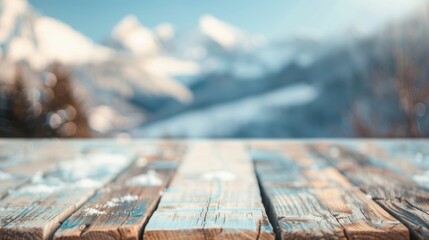 Naklejka premium The wooden table stands against a backdrop of stunning snowy mountains under clear skies, evoking a peaceful winter atmosphere