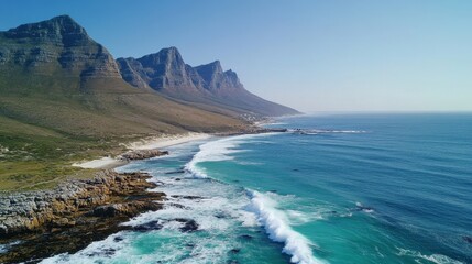 Obraz premium Dramatic Coastal Scenery Aerial View of Mountains Meeting Turquoise Ocean with Crashing Waves.