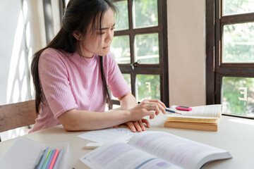 Asian girl student doing exam hand holding pencil writing answer in university classroom education high school or university student taking notes while preparing for exam
