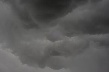 The dark sky with heavy clouds converging and a violent storm before the rain.Bad or moody weather sky and environment. carbon dioxide emissions, greenhouse effect, global warming, climate change.