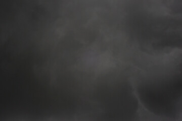 The dark sky with heavy clouds converging and a violent storm before the rain.Bad or moody weather sky and environment. carbon dioxide emissions, greenhouse effect, global warming, climate change.