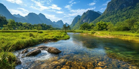 A beautiful nature scene with a clear river flowing through a lush green valley, surrounded by tall mountains.