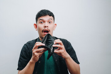 An Expressive Young Man Surprised by an Empty Wallet in a Minimalist Setting