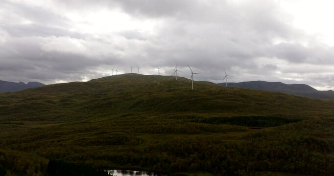 Rotating Wind Turbines Over Mountains Against Cloudy Sky In Sortland, Norway. Aerial Drone Shot