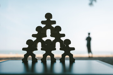 A businessman model standing in a pyramid shape with a successful businessman on top. The concept...