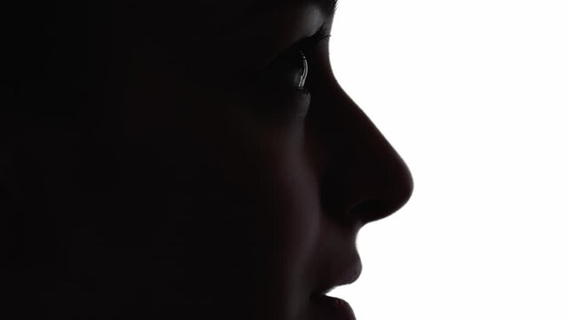 Hopeful face. Prayer silhouette. Dream faith. Dark contrast profile outline of inspired woman looking up isolated on white free space background.