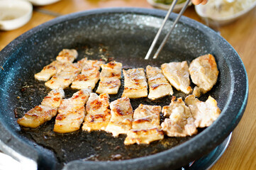 불판 위에서 삼겹살을 맛있게 굽고 있는 모습