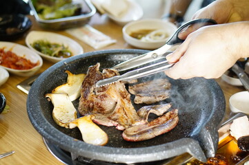 불판 위에서 삼겹살을 맛있게 굽고 있는 모습