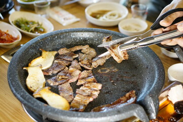 불판 위에서 삼겹살을 맛있게 굽고 있는 모습